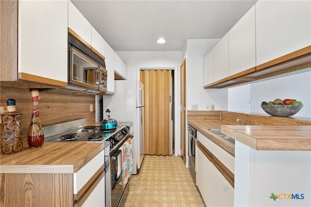 kitchen with light countertops, backsplash, stainless steel range with electric cooktop, white cabinetry, and dishwasher