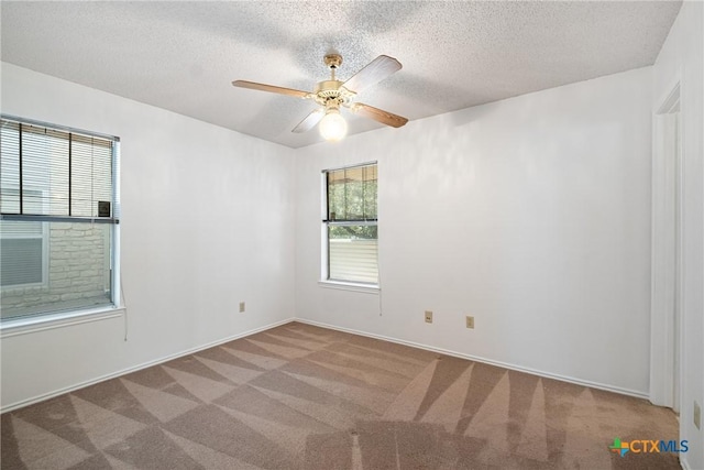 spare room with a ceiling fan, light carpet, and a textured ceiling