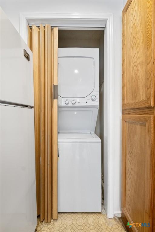 washroom with stacked washer and dryer and laundry area