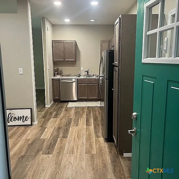 205 Lasalle Rd, Inez, TX 77968 - kitchen with stainless steel dishwasher, dark wood finished floors, freestanding refrigerator, a sink, and recessed lighting
