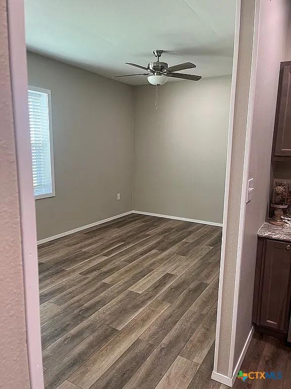 205 Lasalle Rd, Inez, TX 77968 - unfurnished room with a ceiling fan, dark wood-style floors, and baseboards