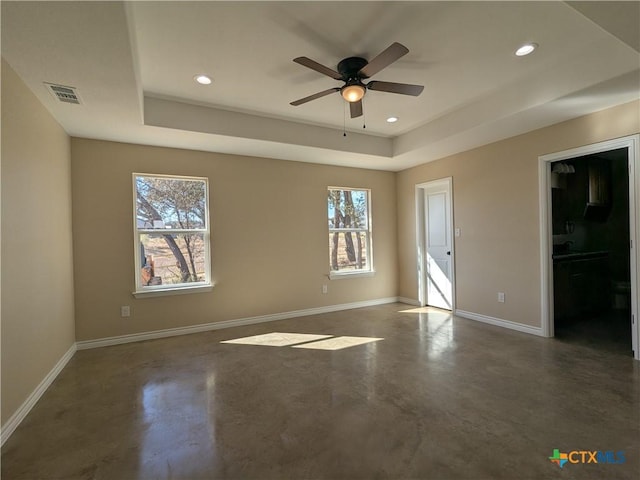 spare room featuring ceiling fan and a tray ceiling