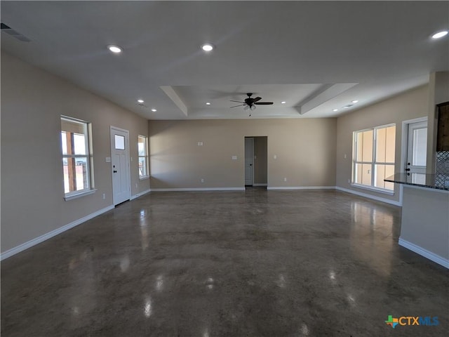 unfurnished living room with a raised ceiling and ceiling fan