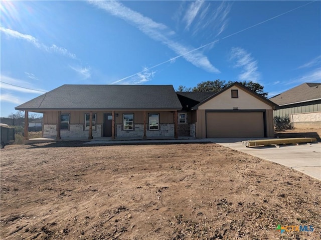 single story home featuring a garage and a porch