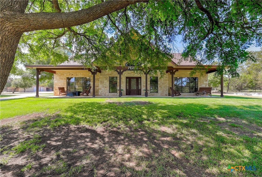 rear view of property with a lawn and a patio