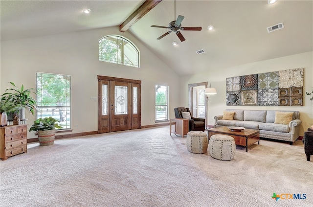 living room featuring plenty of natural light, light carpet, and high vaulted ceiling