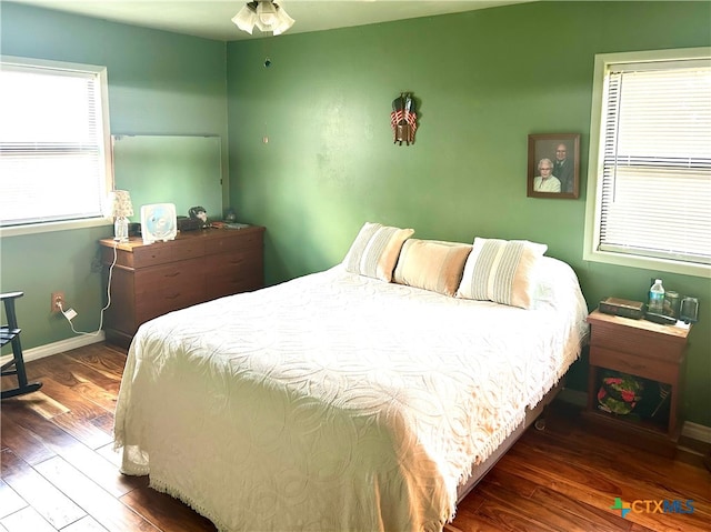 bedroom with dark hardwood / wood-style floors