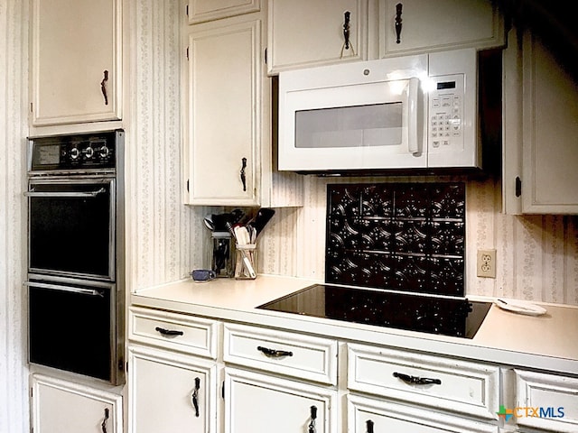 kitchen featuring white cabinetry and black appliances