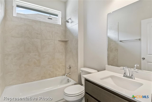 full bathroom with vanity, tiled shower / bath combo, and toilet