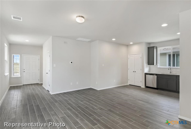 unfurnished living room with dark wood-type flooring and sink