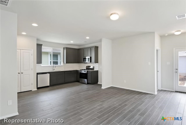 kitchen featuring a wealth of natural light, wood-type flooring, and appliances with stainless steel finishes