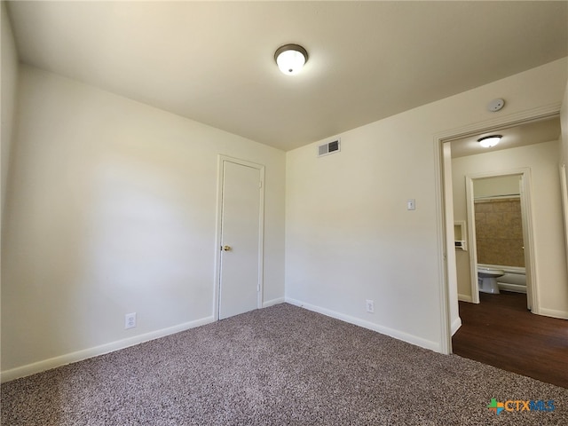 unfurnished room with carpet flooring, visible vents, and baseboards