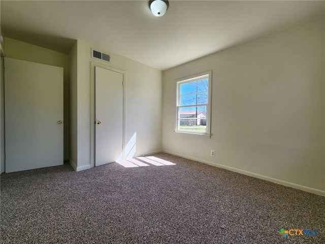 unfurnished bedroom featuring visible vents, carpet floors, and baseboards