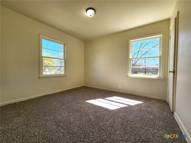 carpeted spare room featuring baseboards and plenty of natural light