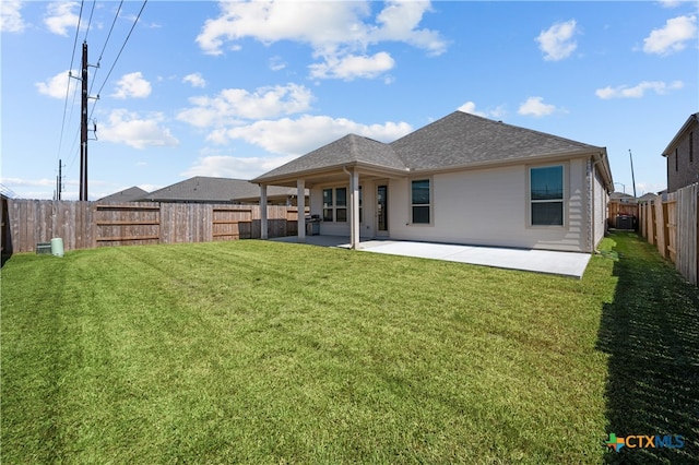 back of house featuring a lawn and a patio area