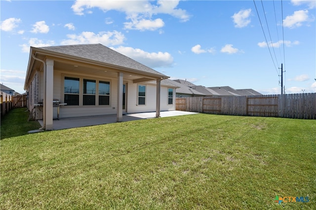 back of house with a lawn and a patio