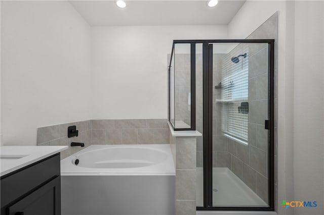 bathroom with independent shower and bath and vanity