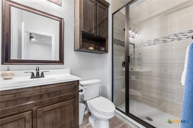 bathroom with vanity, wood-type flooring, an enclosed shower, and toilet