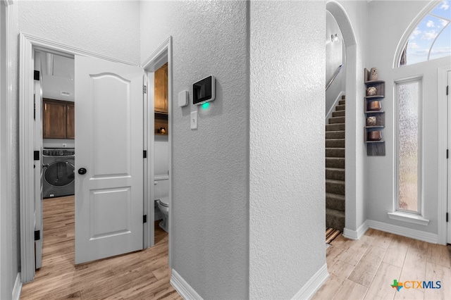 corridor featuring washer / clothes dryer and light hardwood / wood-style floors