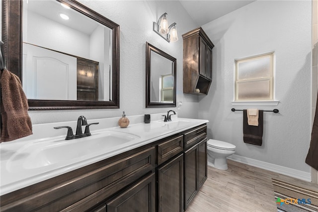 bathroom with hardwood / wood-style floors, vanity, and toilet