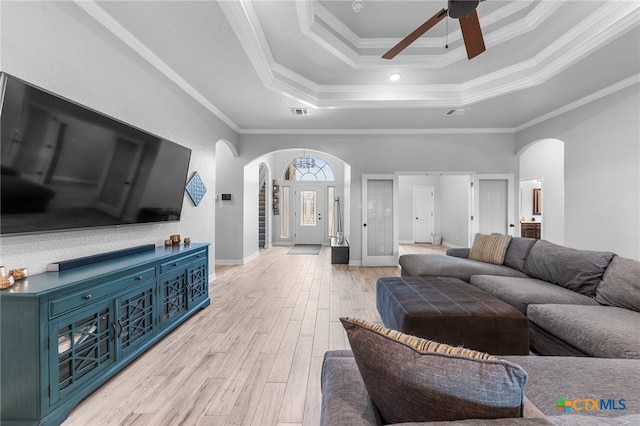 living room with ceiling fan, french doors, a raised ceiling, crown molding, and light wood-type flooring