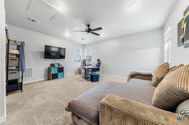 bedroom featuring ceiling fan, light colored carpet, and a textured ceiling