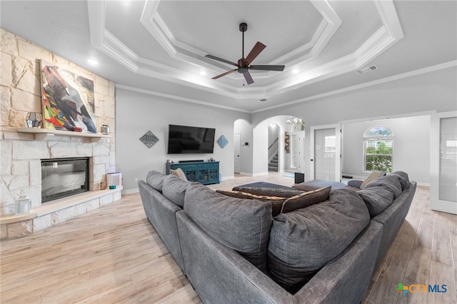 living room with hardwood / wood-style floors, crown molding, and a tray ceiling