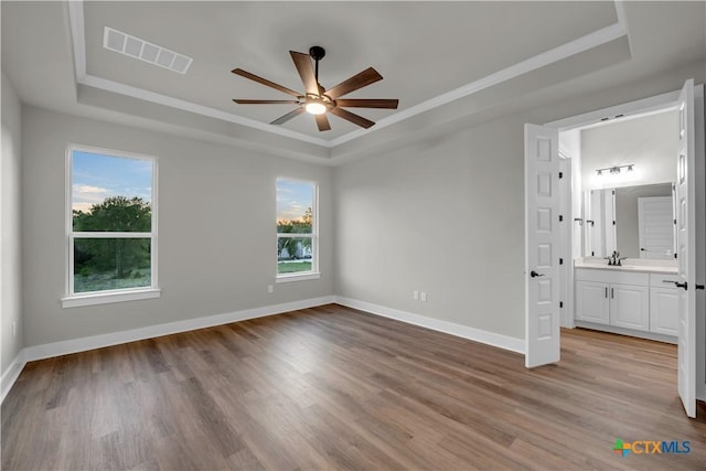 113 Cobblestone Ln, Burnet, TX 78611 - unfurnished bedroom featuring baseboards, wood finished floors, visible vents, and a raised ceiling
