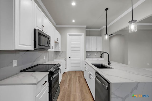 113 Cobblestone Ln, Burnet, TX 78611 - kitchen with white cabinets, a sink, a center island with sink, crown molding, and appliances with stainless steel finishes