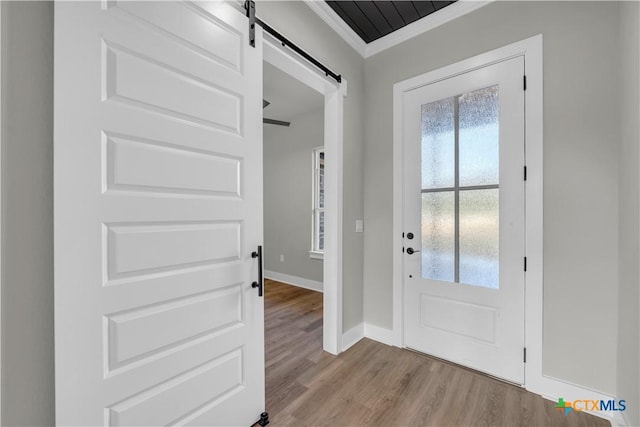 113 Cobblestone Ln, Burnet, TX 78611 - doorway to outside featuring a barn door, wood finished floors, a wealth of natural light, and crown molding
