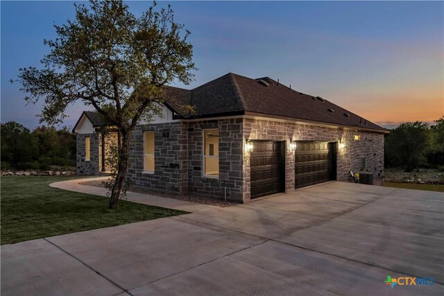 113 Cobblestone Ln, Burnet, TX 78611 - view of front of home with a garage, driveway, stone siding, and a front yard