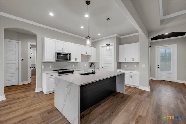 113 Cobblestone Ln, Burnet, TX 78611 - kitchen with baseboards, a sink, arched walkways, and appliances with stainless steel finishes