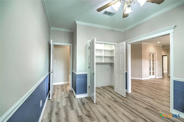 unfurnished bedroom with a closet, light hardwood / wood-style floors, ceiling fan, and crown molding