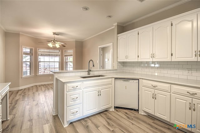 kitchen with dishwasher, white cabinets, sink, tasteful backsplash, and kitchen peninsula