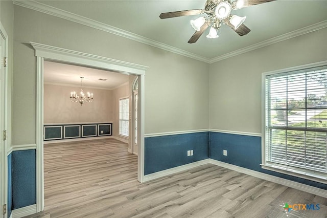 spare room featuring hardwood / wood-style floors, ceiling fan with notable chandelier, and ornamental molding