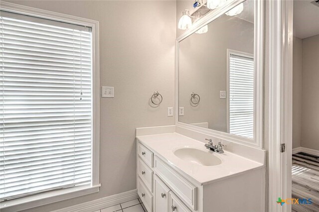 bathroom with tile patterned flooring, vanity, and plenty of natural light