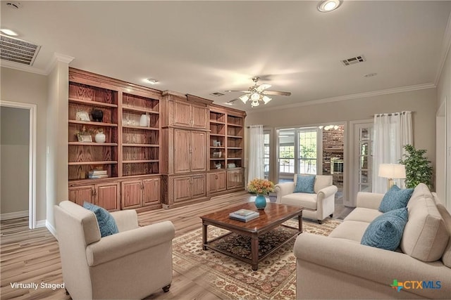 living room featuring ceiling fan, ornamental molding, and light hardwood / wood-style flooring