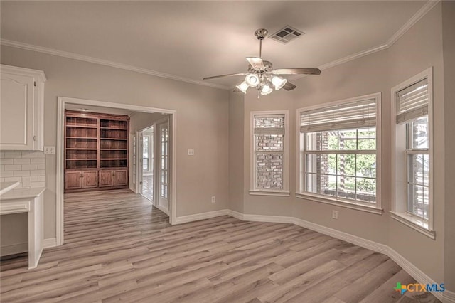 unfurnished dining area with light hardwood / wood-style flooring, ceiling fan, and crown molding