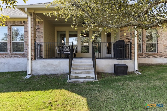 back of property with a lawn and a porch