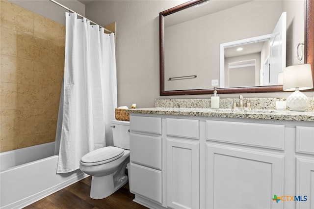 full bathroom featuring hardwood / wood-style floors, vanity, shower / tub combo, and toilet