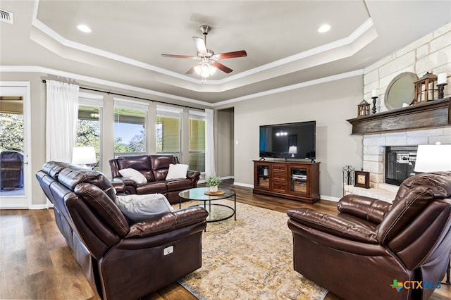 living room with a raised ceiling, plenty of natural light, and dark wood-type flooring