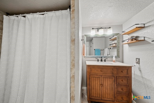 bathroom with vanity, curtained shower, and a textured ceiling