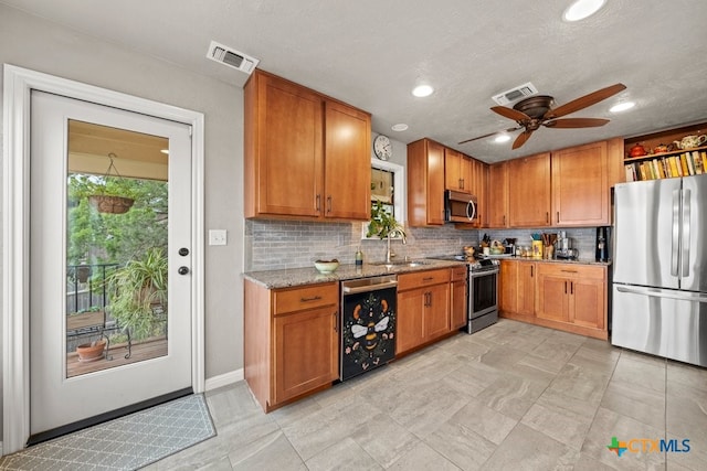 kitchen featuring tasteful backsplash, ceiling fan, stainless steel appliances, and light stone counters