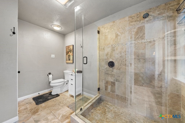 bathroom featuring a textured ceiling, vanity, toilet, and walk in shower