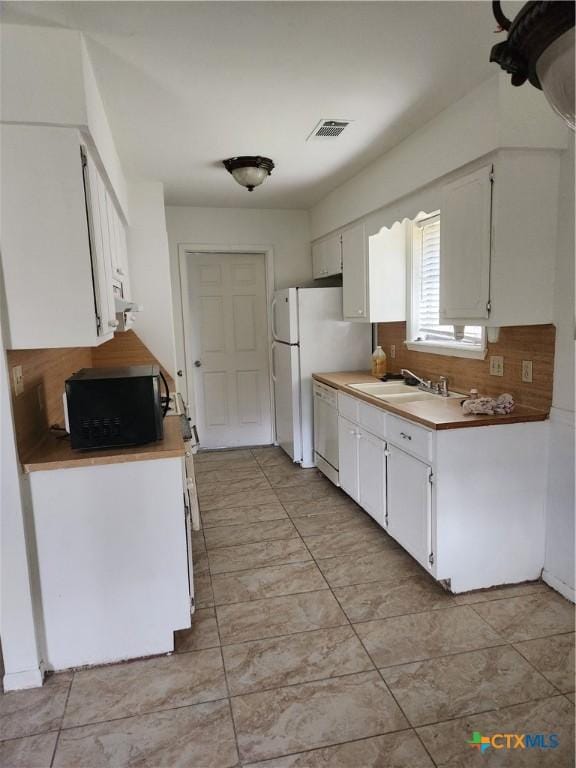 kitchen with sink, white cabinets, dishwasher, and tasteful backsplash