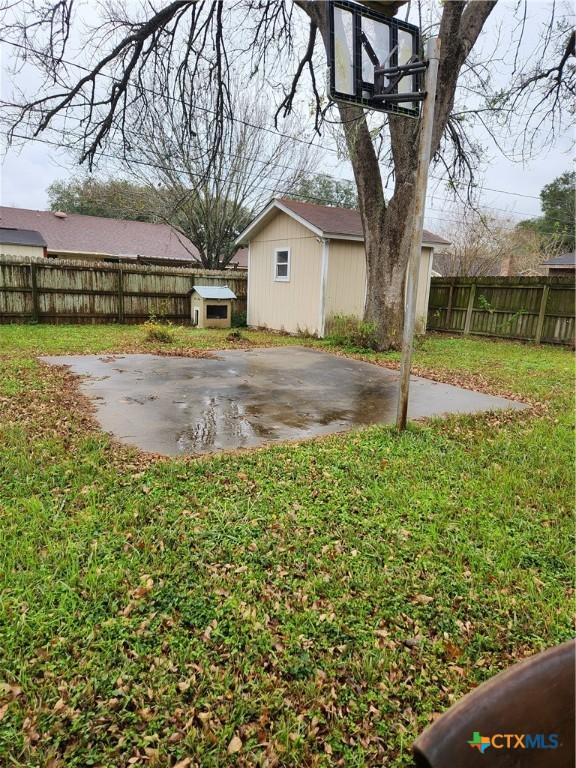 view of yard featuring an outbuilding, basketball court, and a patio