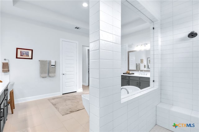 bathroom with tiled shower and vanity