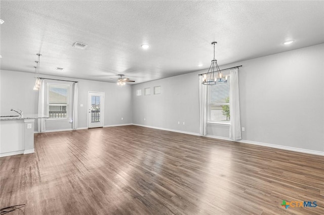 7917 Purvis St, Temple, TX 76502 - unfurnished living room featuring healthy amount of natural light, wood finished floors, a textured ceiling, a ceiling fan, and recessed lighting