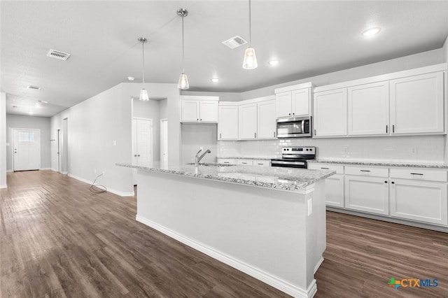 7917 Purvis St, Temple, TX 76502 - kitchen featuring appliances with stainless steel finishes, dark wood-style flooring, white cabinets, backsplash, and a center island with sink