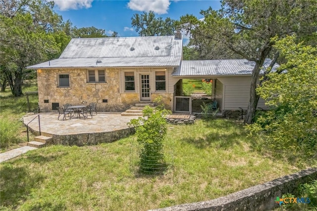 959 Highland Dr, Bandera, TX 78003 - back of property featuring a patio area, stone siding, a lawn, and a metal roof
